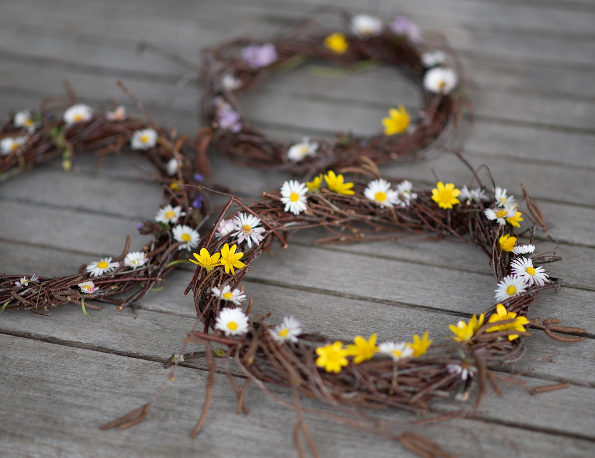 Two rustic wreaths adorned with small wildflowers
